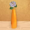 Orange color long metal vase with a sturdy base for home décor.